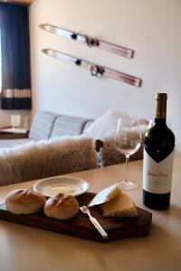 una mesa con una botella de vino y pan y una copa de vino en Mountain Aparts Cirrus en Las Lenas