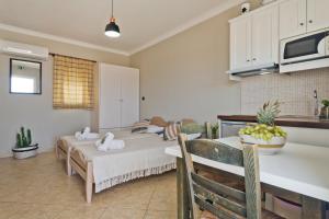 a kitchen and living room with two beds and a table at Kalimera Karpathos Exclusive Villas in Afiartis