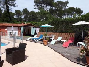 un patio avec des chaises et des parasols à côté d'une piscine dans l'établissement Hotel Albatros, à Mouans-Sartoux