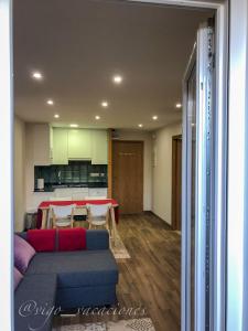 a living room with a blue couch and a kitchen at Pizarro55 By Vigovacaciones in Vigo