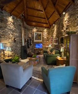 a living room with couches and a stone wall at Casa Camino Turismo Rural in Palas de Rei 