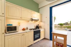 a kitchen with a microwave and a stove top oven at The "Perfect Beach House" Villa in Lakhania