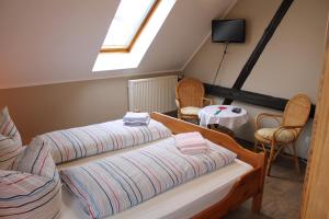 um quarto no sótão com 2 camas e uma mesa em Landhotel Belitz Garni em Küsten