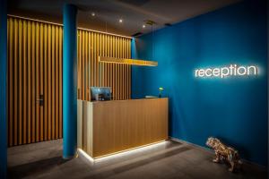 a reception room with a blue wall and a reception desk at Baxter Hotel in Visp