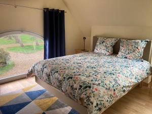 Kerloulou في Poullan-sur-Mer: غرفة نوم بسرير ونافذة