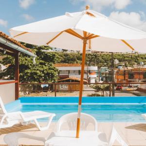 um guarda-chuva branco sentado ao lado de uma piscina em Hotel Sol Bahia em Porto Seguro