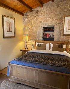 a bedroom with a bed and a stone wall at Casa Camino Turismo Rural in Palas de Rei 