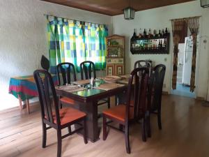 a dining room with a wooden table and chairs at Sítio Bosque Magico in Nova Friburgo