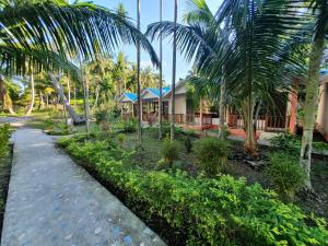 une maison avec des palmiers et une passerelle dans l'établissement Blue Lagoon Resort, Neil Island, à Neil Island
