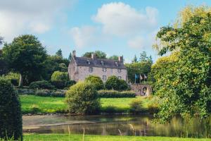 una casa vieja en un campo junto a un lago en Appartement de charme au Manoir !, en Le Relecq-Kerhuon