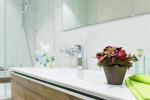 a bathroom counter with a vase with a plant on it at Jolimont Apartments in Zermatt