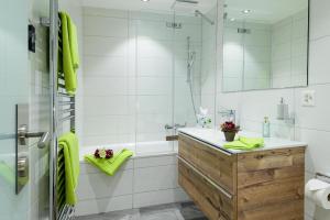 bagno con vasca, lavandino e doccia di Jolimont Apartments a Zermatt