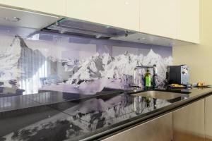 a kitchen with a mountain mural on the wall at Jolimont Apartments in Zermatt +98 photos