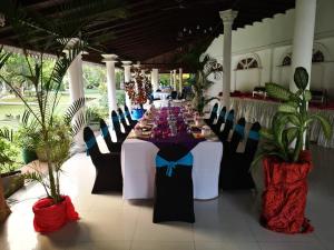 a long table in a room with tables and chairs at Bougain Villa in Bentota