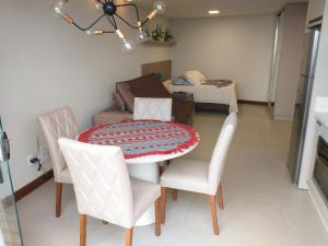 a dining room with a table and two chairs at Residence Farol - Loft 219 in Laguna