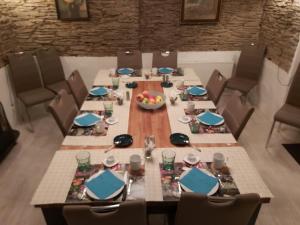 una mesa en un comedor con sillas y una mesa con comida en La Fermette Blanche, en Nadrin
