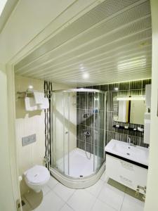 uma casa de banho com um chuveiro, um WC e um lavatório. em ANKARA ATLANTİK OTEL em Etimesut