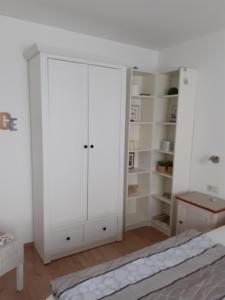 una camera da letto con un armadio bianco e un letto di Ferienwohnung Tonbachtal a Baiersbronn