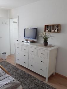 eine weiße Kommode mit einem TV darüber in der Unterkunft Ferienwohnung Tonbachtal in Baiersbronn