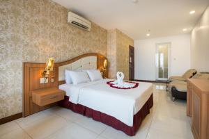 1 dormitorio con 1 cama y sala de estar con sofá en Lam Kinh Hotel en Ho Chi Minh