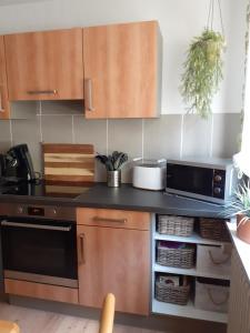 eine Küche mit Holzschränken und einer schwarzen Arbeitsplatte in der Unterkunft Ferienwohnung Tonbachtal in Baiersbronn