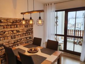 a dining room with a table and chairs and a brick wall at Ferienwohnung Waldzauber in Bärenstein