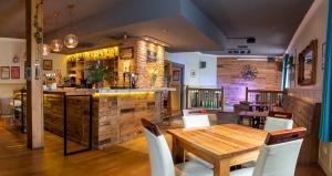 un restaurante con una mesa de madera y un bar en The Walnut Tree Inn en Northampton