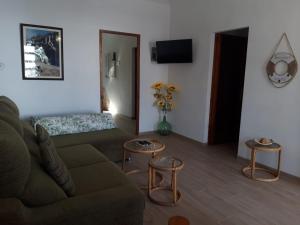 VILLA FLOR في كالا فيغويرا: غرفة معيشة مع أريكة وطاولتين