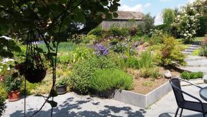 un jardin avec des fleurs et des plantes dans une cour dans l'établissement Le Clos Marie, à Ciney