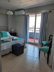 Un dormitorio con una cama y una silla y una ventana. en Boulevard Lavalle Apartament, en San Miguel de Tucumán