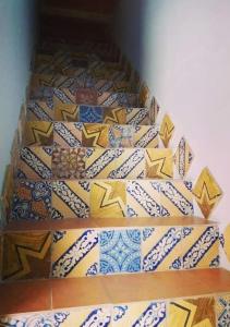 a stair case with colorful tiles on the wall at Appartamento centralissimo in Castellammare del Golfo