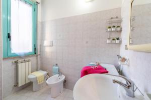La salle de bains blanche est pourvue d'un lavabo et de toilettes. dans l'établissement Ippocampo Silvi Vacanza, à Silvi Marina