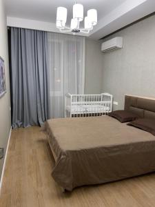 アドレルにあるApartment in Mandarin Parkのベッドルーム1室(ベッド1台、ベビーベッド1台付)