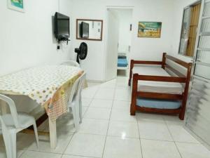 a room with a table and chairs and a television at Chalés Boraceia Duda in Boracéia