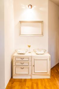 a white dresser with two bowls on top of it at Stairway to the castle in Ljubljana