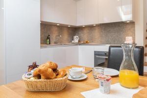 a table with a basket of bread and a bottle of orange juice at Jolimont Apartments in Zermatt
