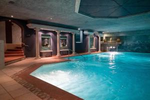 a large indoor swimming pool in a building at Hotel Eden Wellness in Zermatt