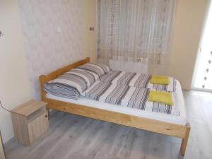 a wooden bed in a room with a window at Green Szálláshely in Debrecen +34 photos