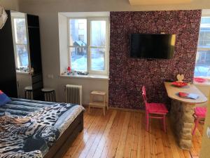 1 dormitorio con cama, mesa y TV en Schwanenburg rest, en Gulbene