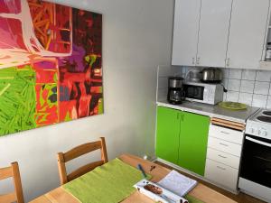 uma cozinha com uma mesa e um quadro na parede em Kiva majoitus 1-4hlö, 500m keskustaan, parkkipaikka em Oulu