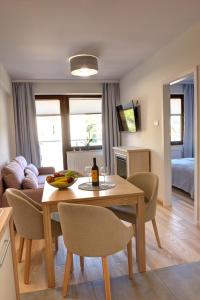 een keuken en een woonkamer met een tafel en stoelen bij Apartamenty KORAL in Krynica Zdrój