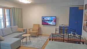 a living room with a couch and a tv on the wall at Apartments Tahko in Tahkovuori +40 photos