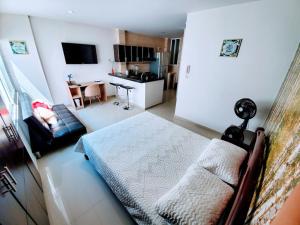 uma sala de estar com uma cama e uma cozinha em Apartaestudio Arboleda del Ingenio em Cali