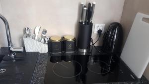 un mostrador negro con algunos utensilios de cocina. en SouvenirAppart Wilenska, en Bydgoszcz