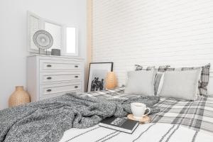 a bedroom with a bed with a blanket and a cup of coffee at Apartament Biała Perła in Czarny Dunajec