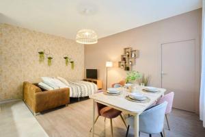 un soggiorno con tavolo e divano di LocationsTourcoing - Le 100 a Tourcoing