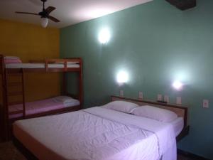 a bedroom with two bunk beds and a ceiling fan at Pousada Flamingo in Búzios