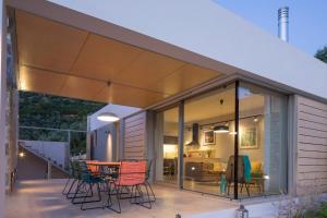 a glass extension of a house with chairs and a table at Atrium Villas in Kechria