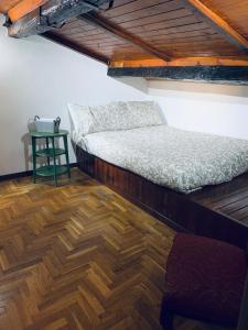 a bedroom with a bed and a table on a wooden floor at Linhouse in Rome