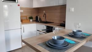 a kitchen with two plates and wine glasses on a counter at Apartament przy Onkologii in Bydgoszcz